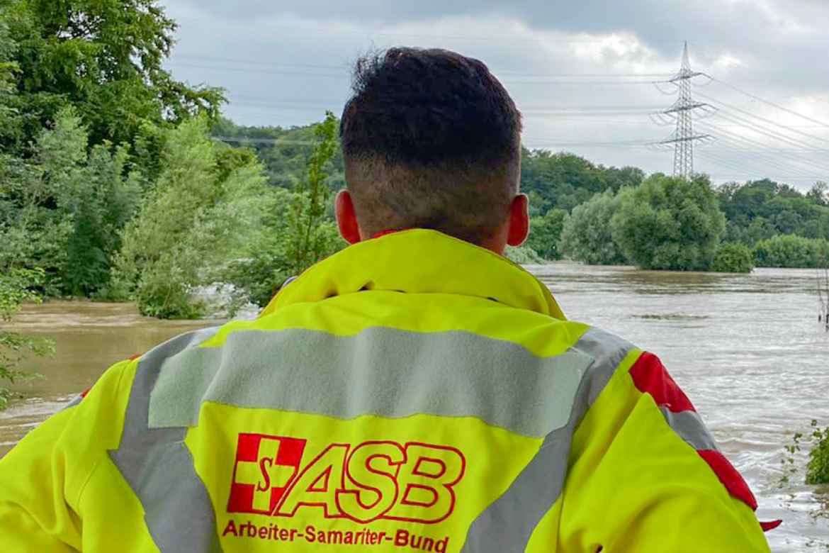 ASB_Hochwasser_2021.jpg Ein Helfer des ASB schaut fassungslos über eine Hochwasserfläche.