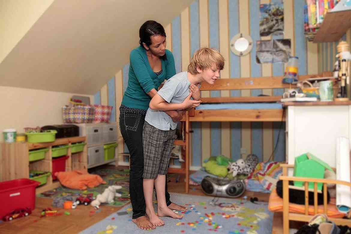 Erste-Hilfe-Kindernotfälle.jpg Eine junge Frau hilft einem Jungen, der sein Lego-Spielzeug verschluckt hat, mit einem kräftigen Druck unterhalb des Brustkorbes.